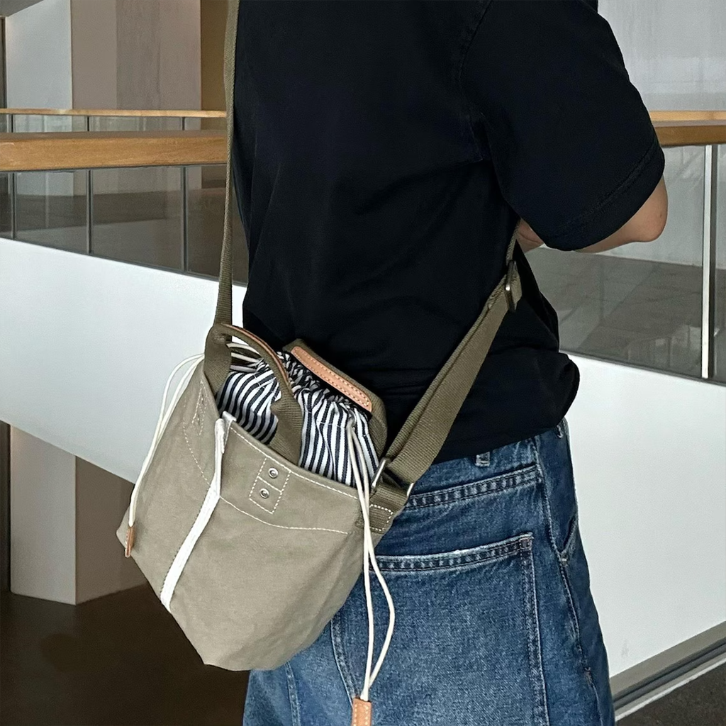 Muted Khaki Woven Mini Bucket Pouch With White Contrast Stitching, Drawstring Striped Liner And Woven Top Hand Loops
