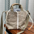 Muted Khaki Woven Mini Bucket Pouch With White Contrast Stitching, Drawstring Striped Liner And Woven Top Hand Loops